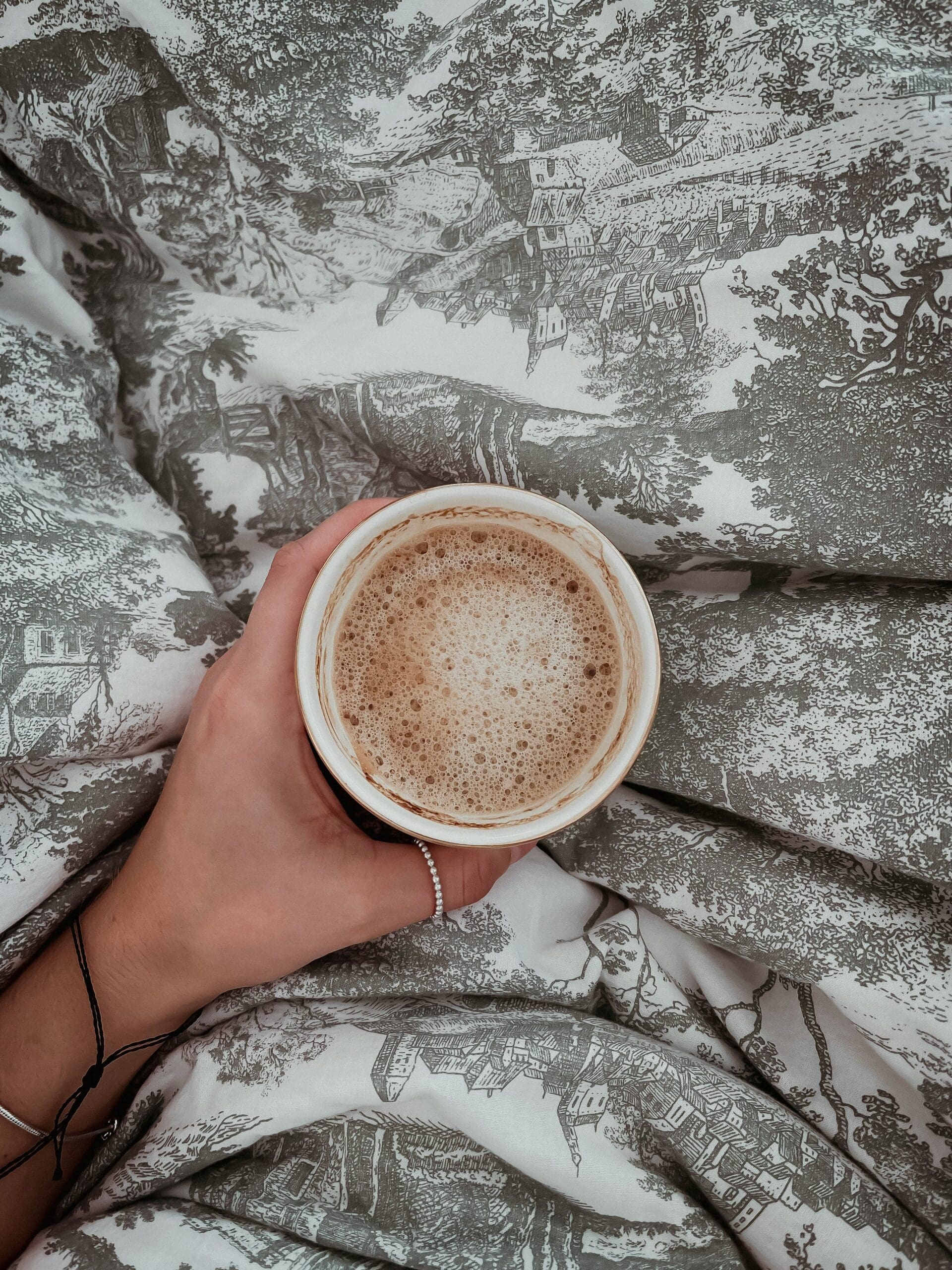 Person holding a warm drink in a calm setting, reflecting on emotionally healthy goals for the new year