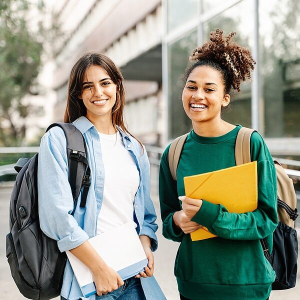Two College Student female friends smiling ready for classes at the University campus